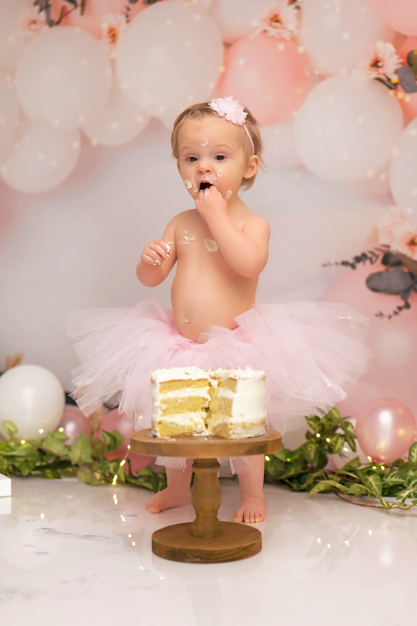 Séance smash the cake en studio, bébé debout près de son gâteau