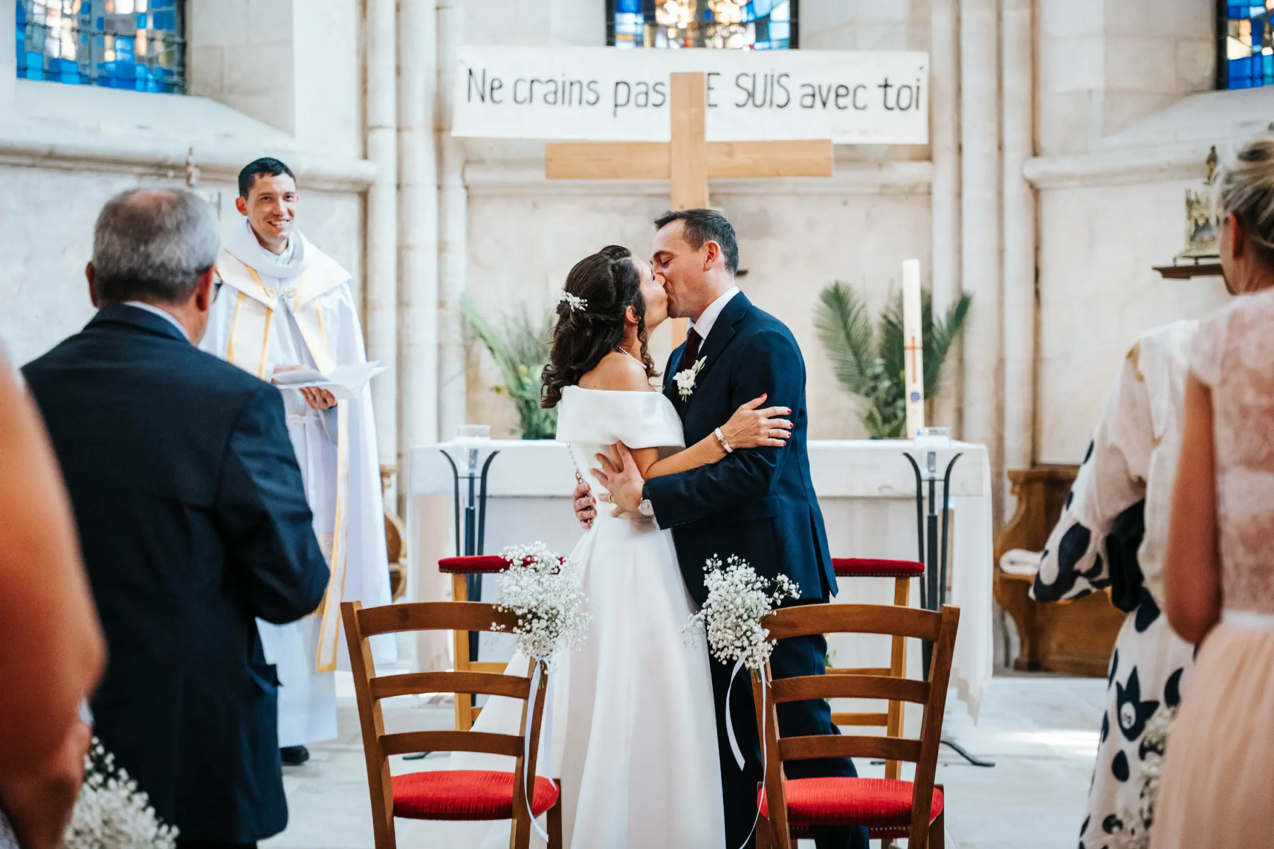 mariés qui s'embrassent pendant la cérémonie religieuse