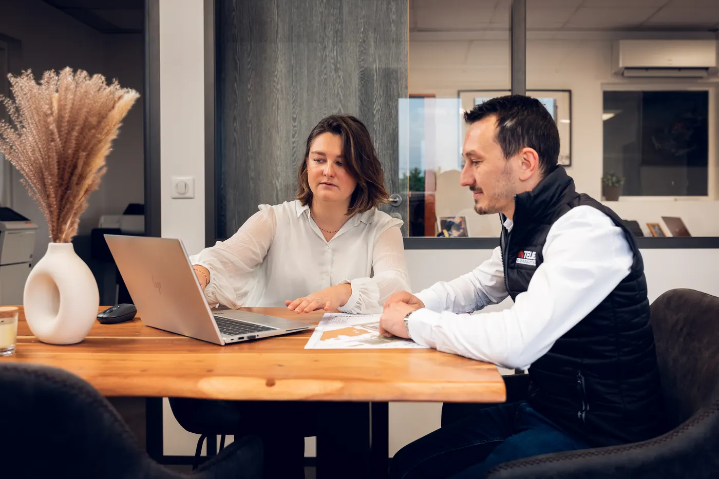 Deux collaborateurs d’Atelier Consulting travaillent ensemble devant un écran