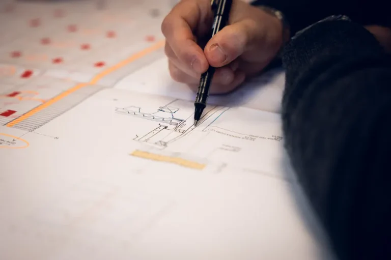 Annotation d’un plan technique au feutre, détail d’une réunion de travail