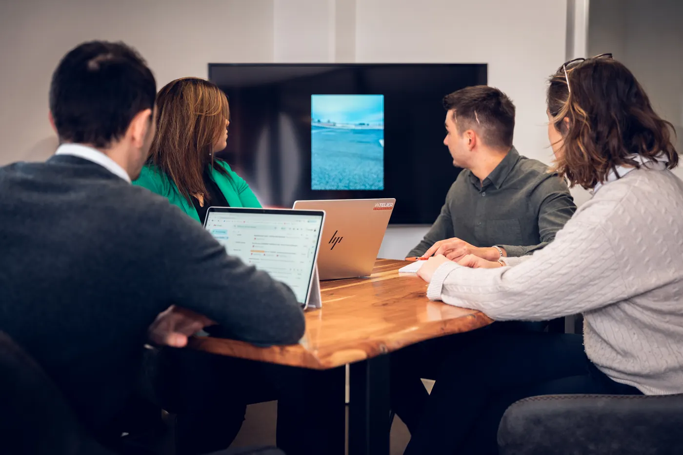 Réunion de travail à quatre autour d’une table, dans les bureaux d’Atelier Consulting