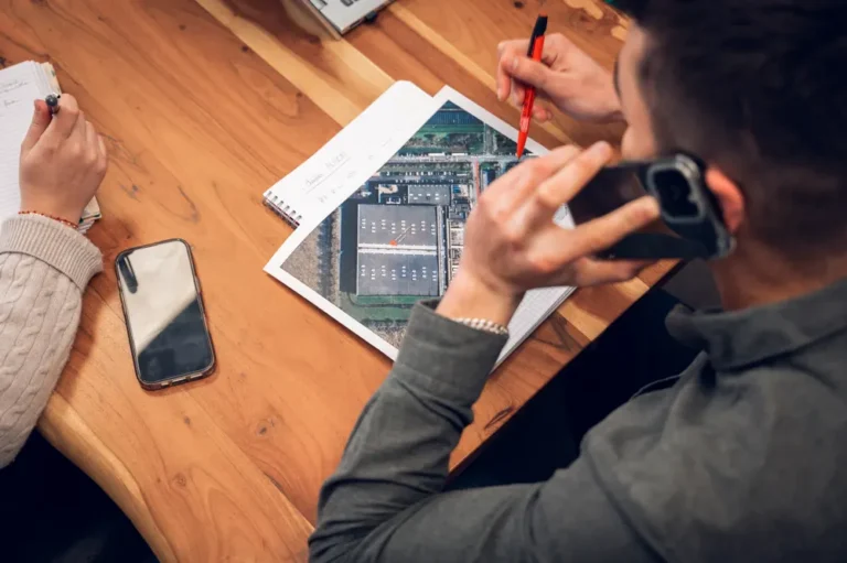 Un collaborateur au téléphone, plan aérien du site industriel sous les yeux