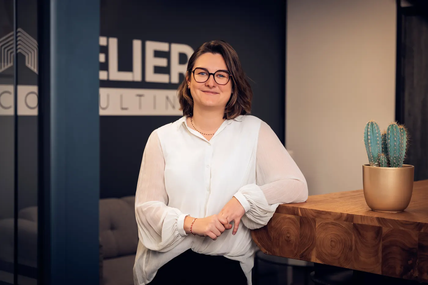 Portrait d’une collaboratrice sur fond blanc, dans les bureaux d’Atelier Consulting